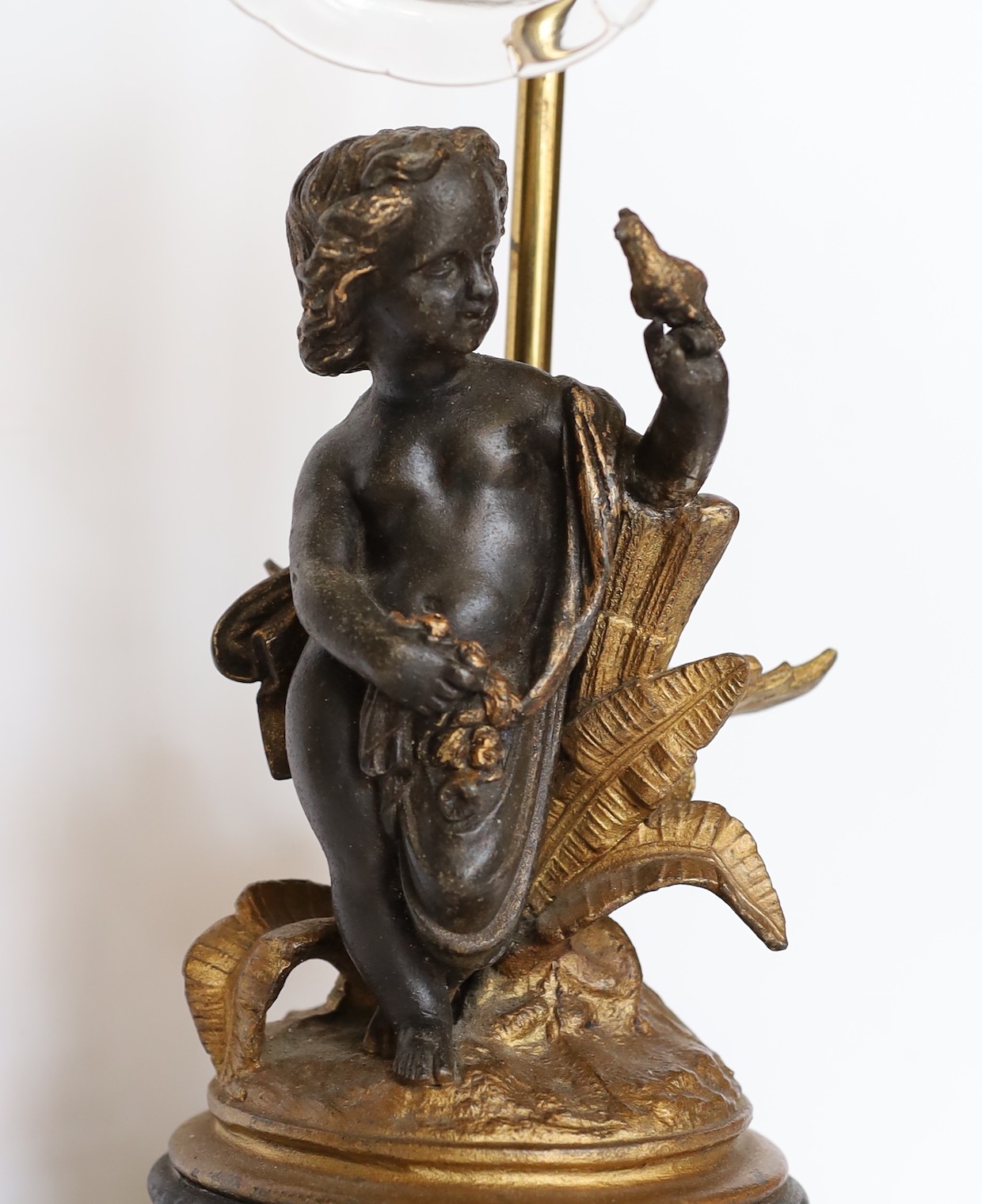 An Edwardian bronze spelter and brass table lamp with cut glass shade, height 46cm